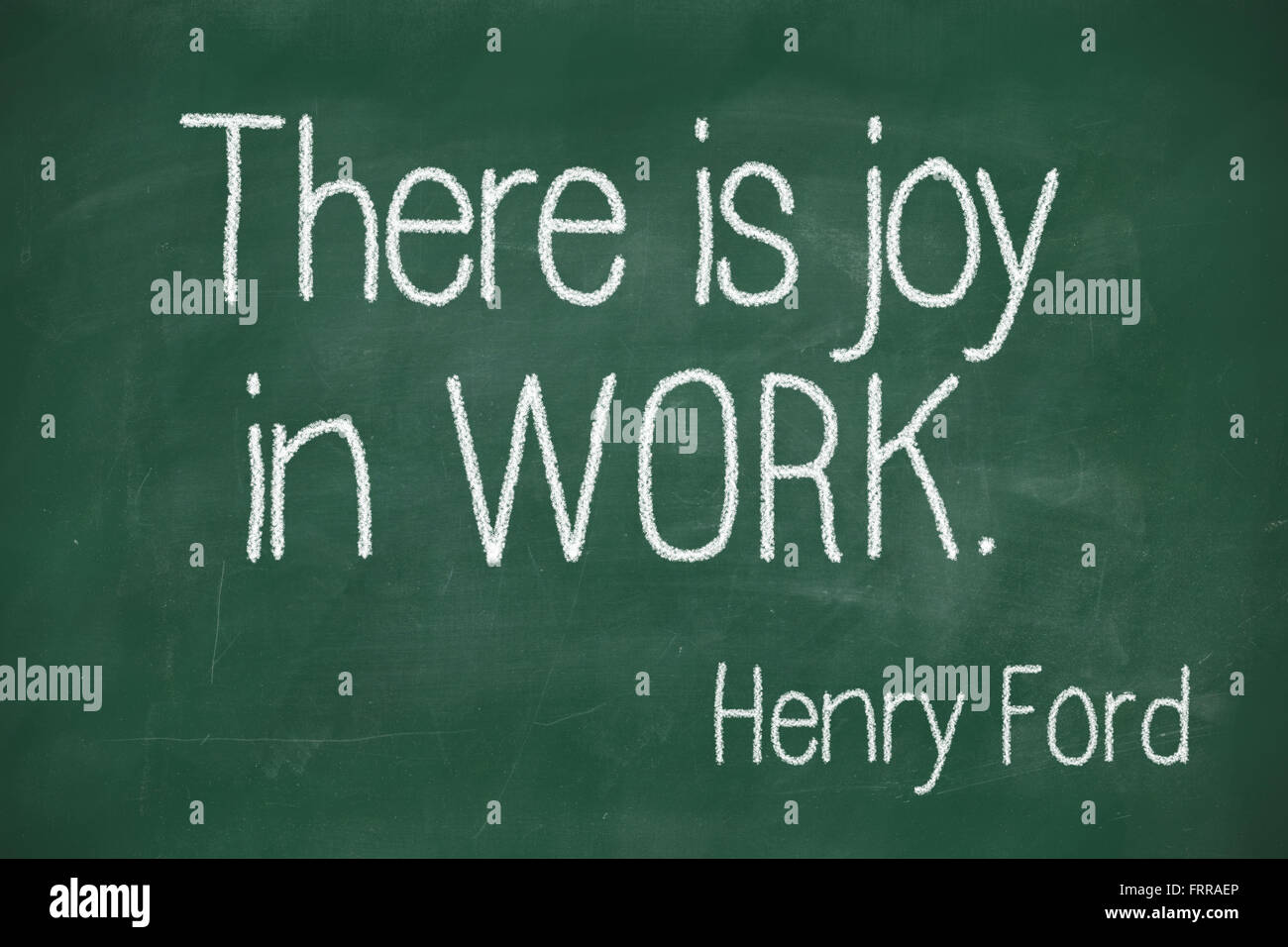 famous Henry Ford quote "There is joy in work." handwritten on blackboard Stock Photo