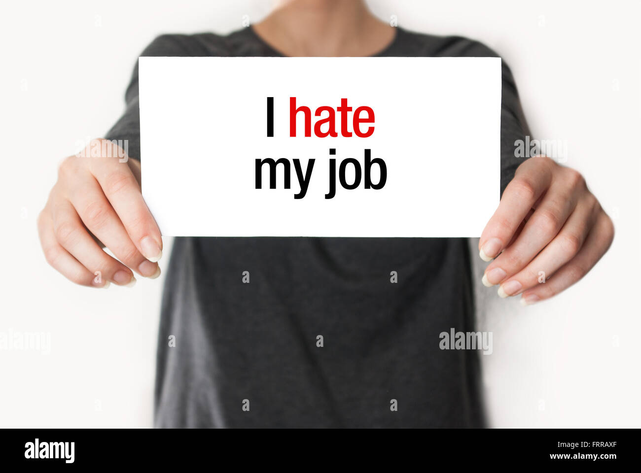 Girl or employee holding showing card with text I hate my job Stock Photo