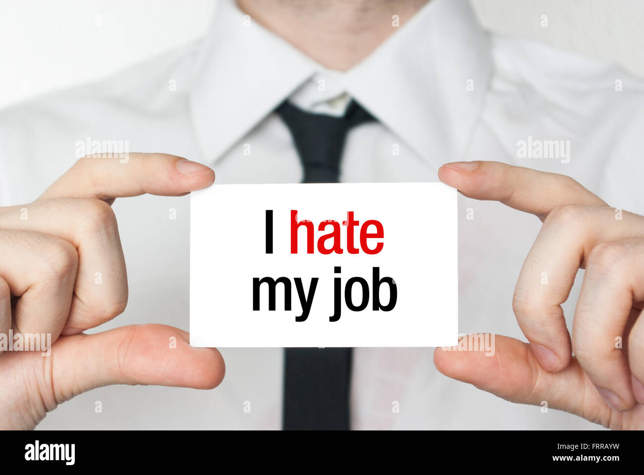 Businessman or employee holding showing card with text I hate my job Stock Photo