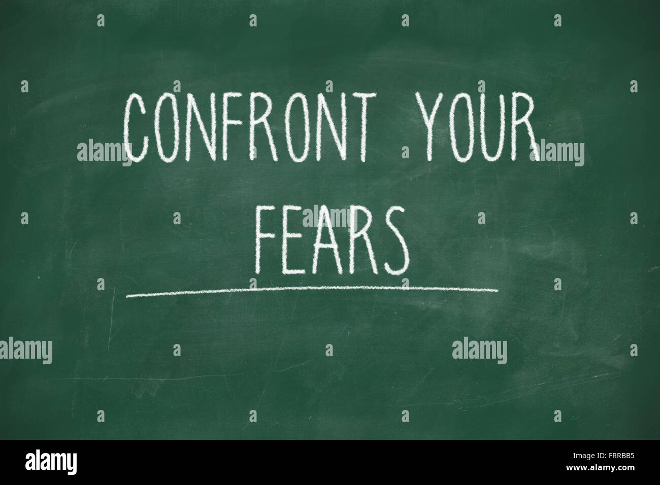 Confront your fears handwritten on school blackboard Stock Photo