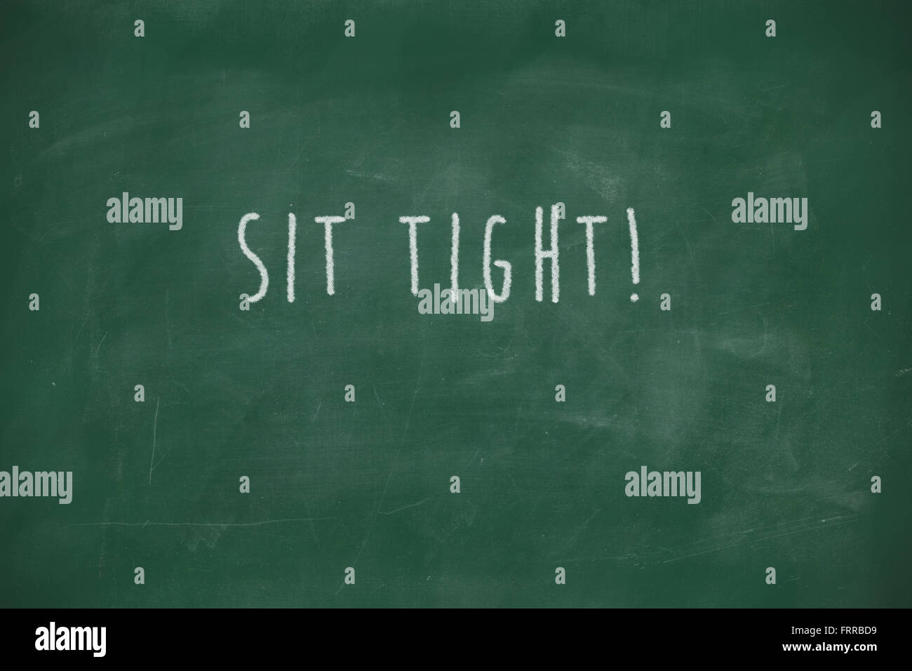 Sit tight handwritten on school blackboard Stock Photo