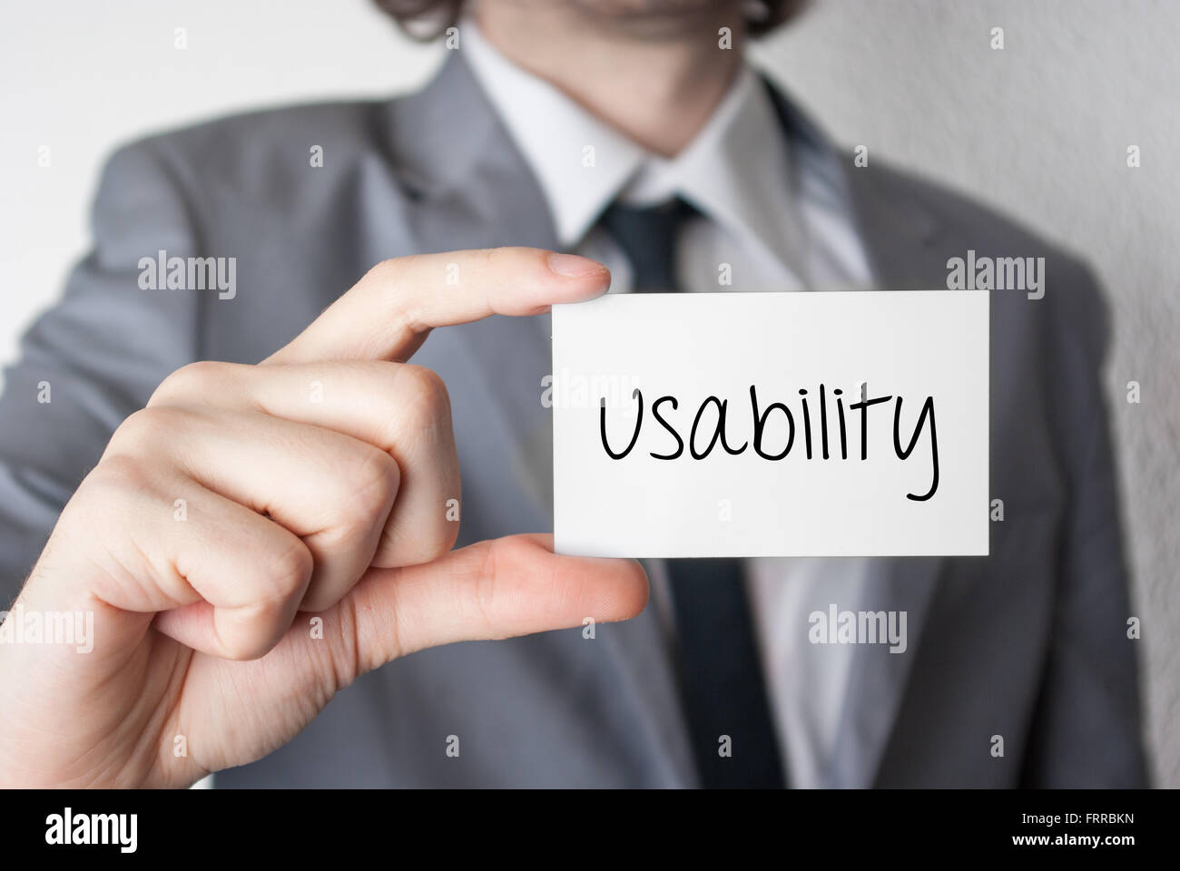 Usability. Businessman in suit with a black tie showing or holding business card Stock Photo