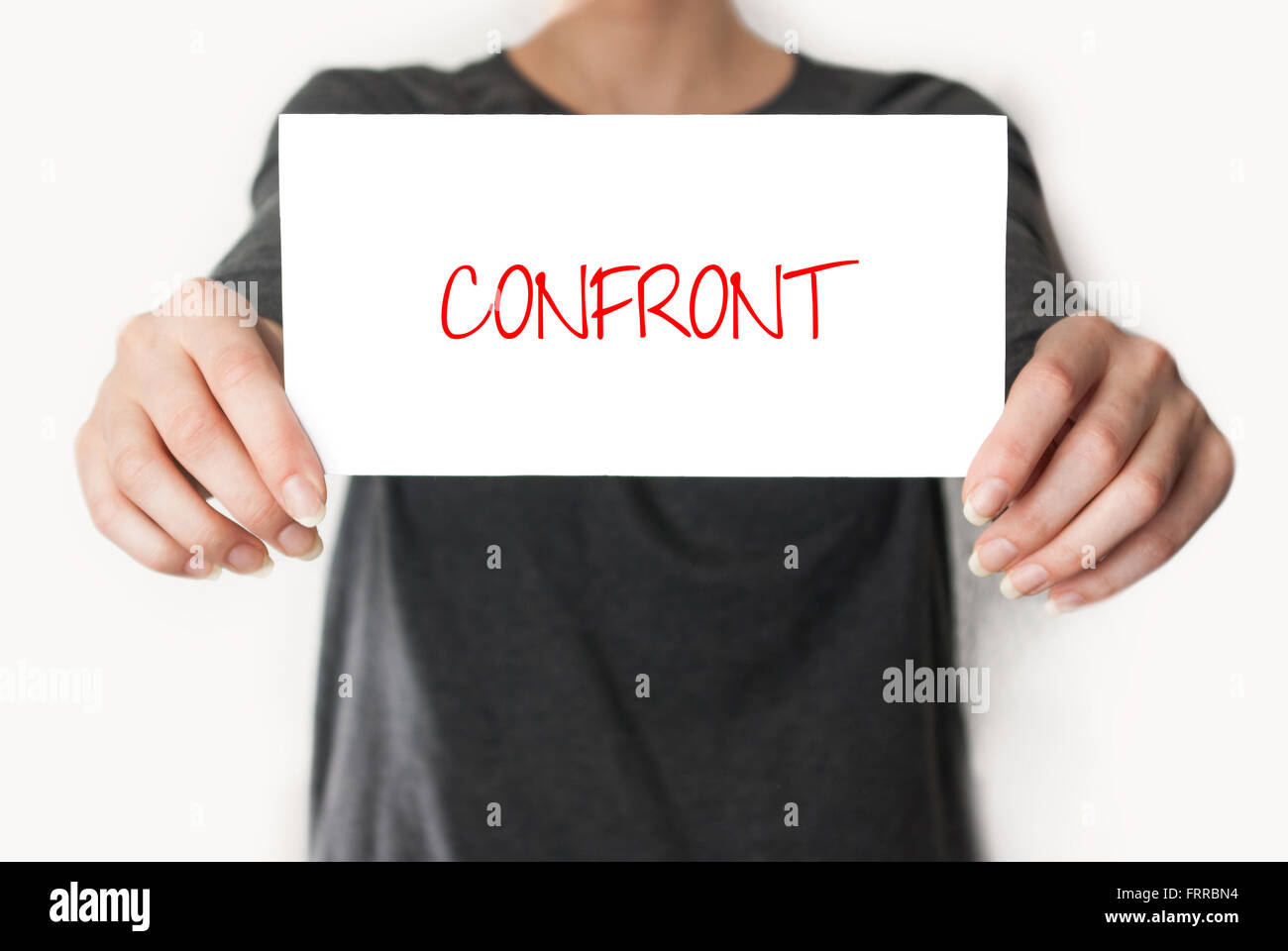 Confront. Female in black shirt showing or holding a card Stock Photo