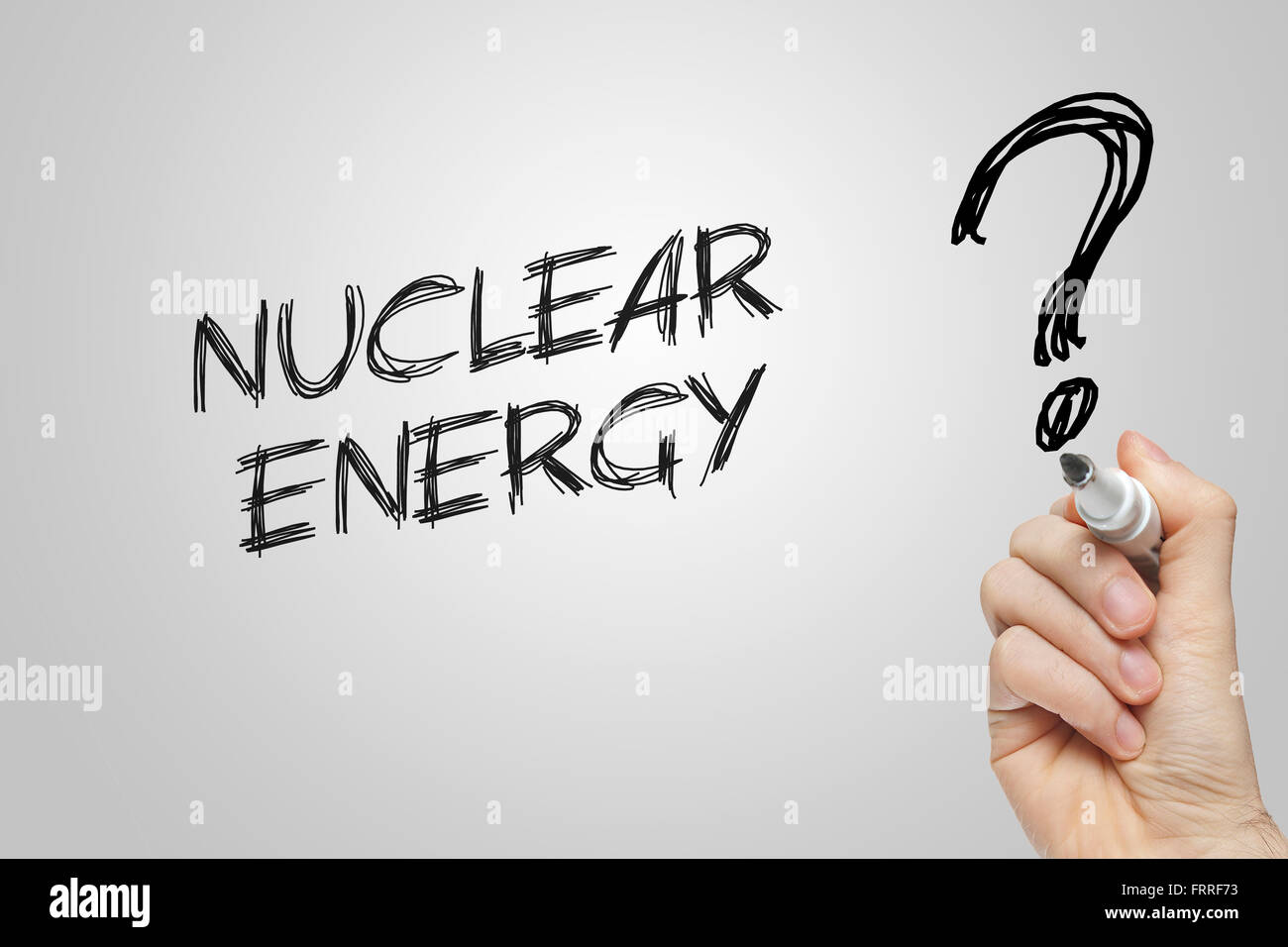 Hand writing nuclear energy on grey background Stock Photo