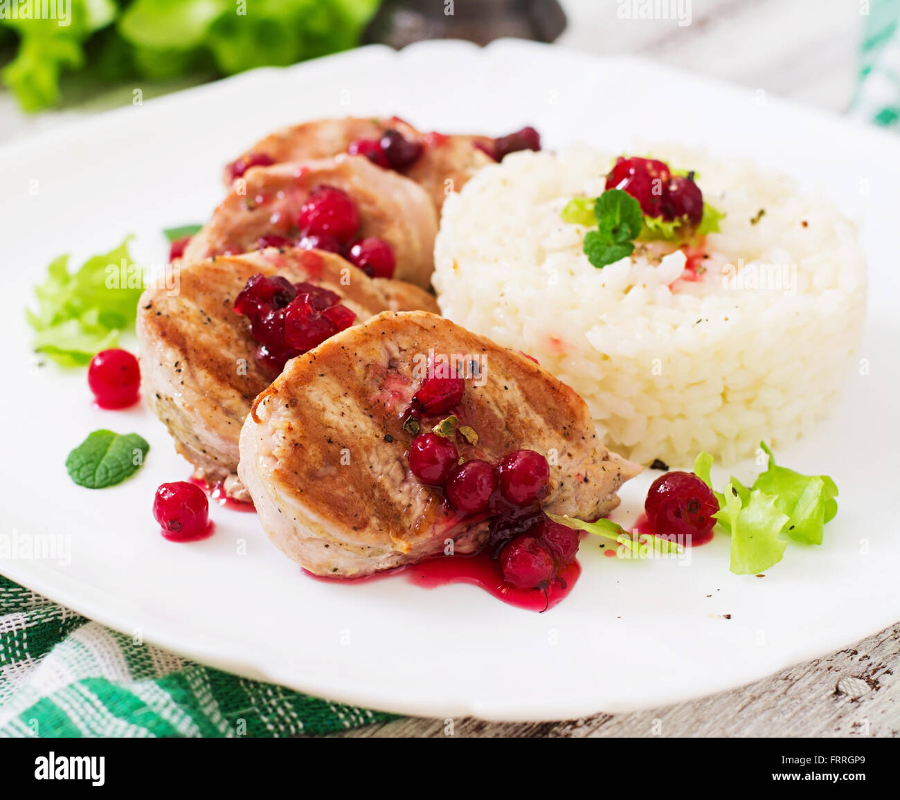 Pork medallions steak with cranberry sauce and a side dish of rice