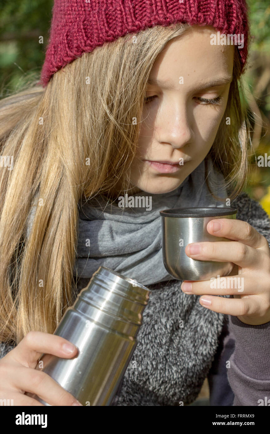 Girl drinks tea from a thermos Stock Photo