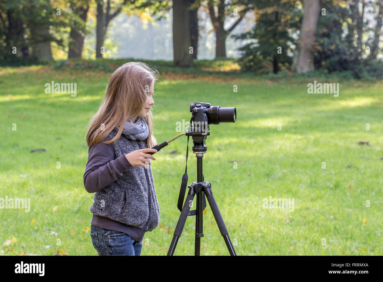 Young girl with a camera on a tripod Stock Photo