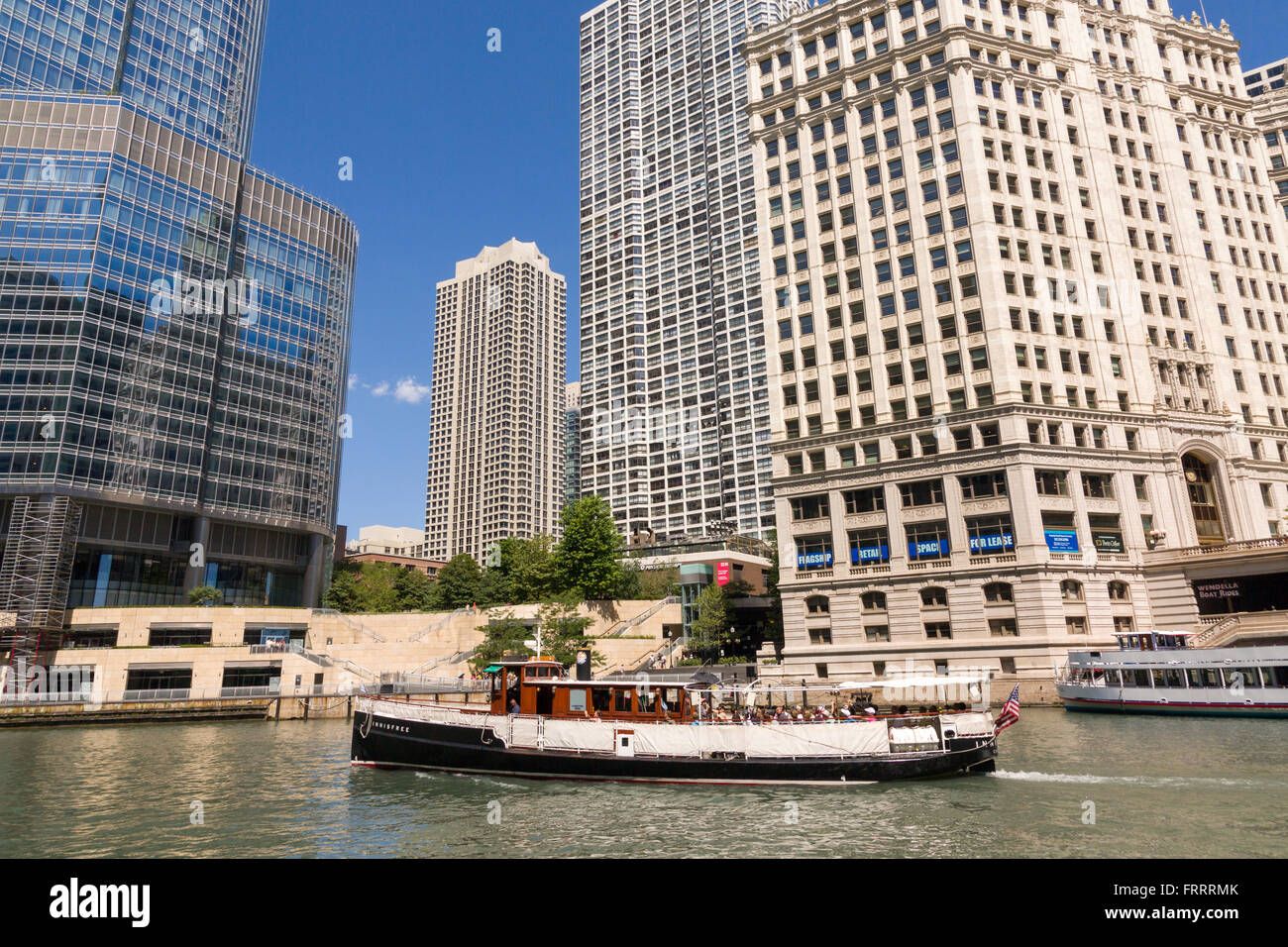 A boat tour travels down the Chicago River past the Wrigley Building on a summers day in Chicago, Illinois, USA Stock Photo
