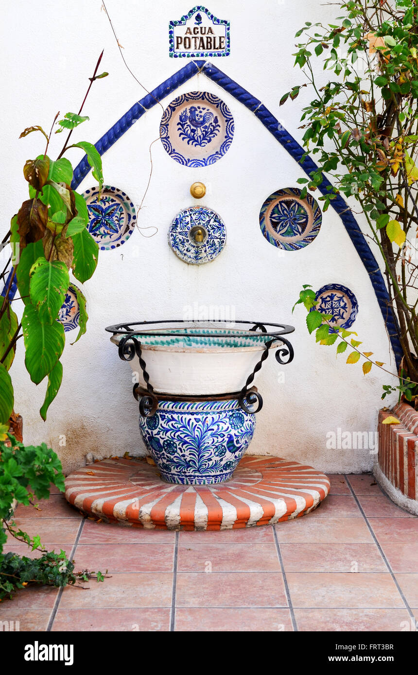 Traditional decorative glazed ceramic agua potable sign. Drinking water sign with water tap in situ in Spanish garden Stock Photo