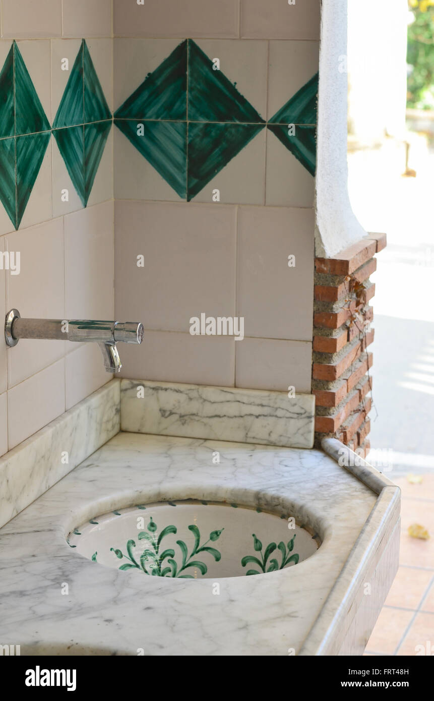 Ornate, decorative ceramic hand-painted Spanish style sink and wall tiles Stock Photo