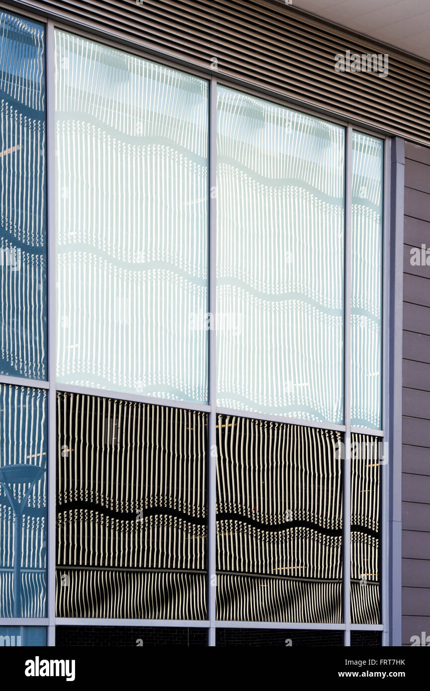 Wavy steelwork architecture on a multi Story car park reflected in glass windows abstract. Milton Keynes, Buckinghamshire, UK Stock Photo