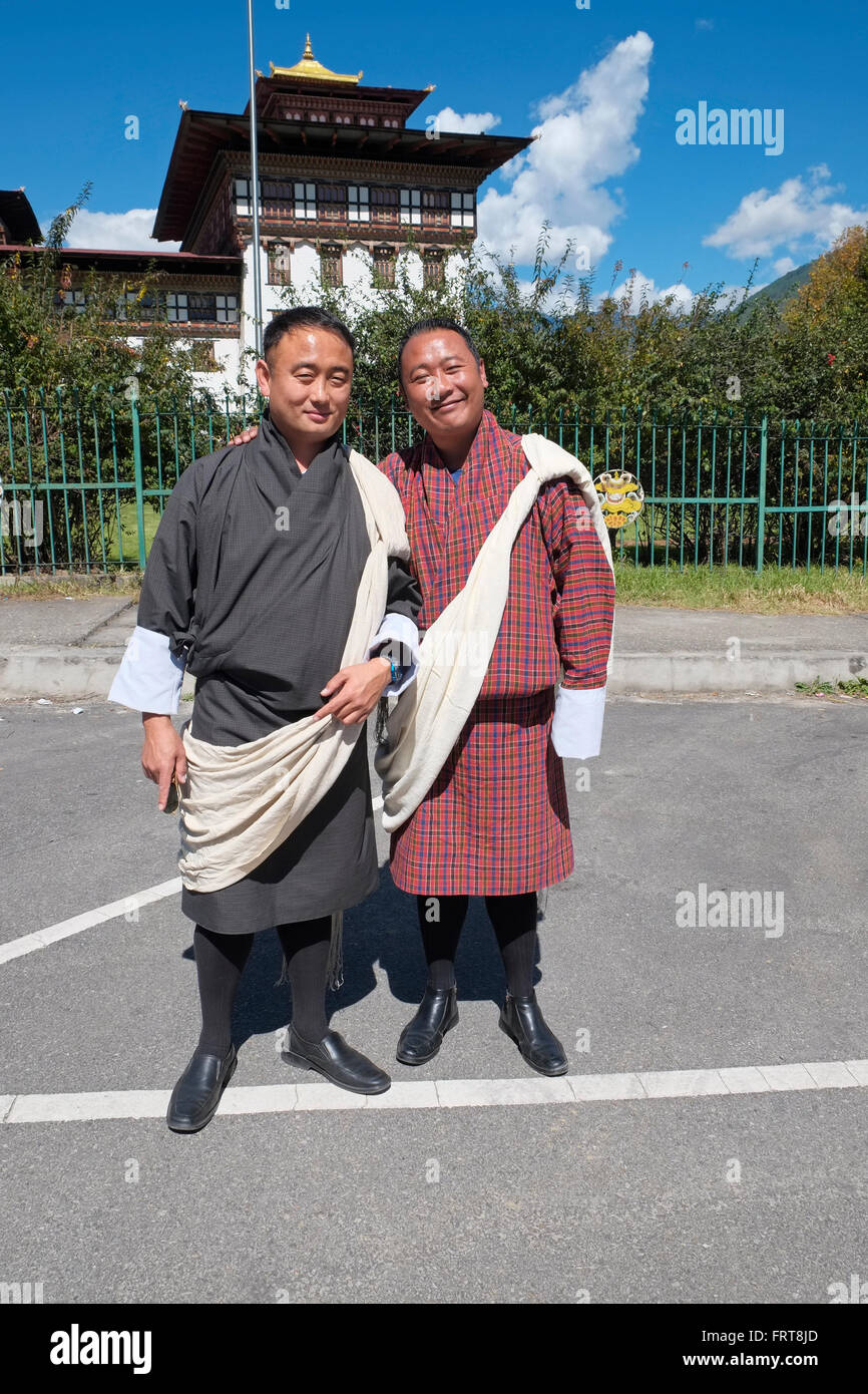 Tour guides wearing the Gho, the traditional national Bhutanese dress for men. Tashichho Dzong, Thimphu, Bhutan. Stock Photo