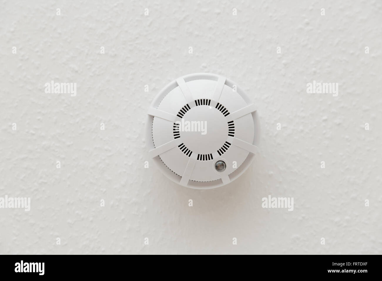 White smoke detector on ceiling in closeup Stock Photo - Alamy