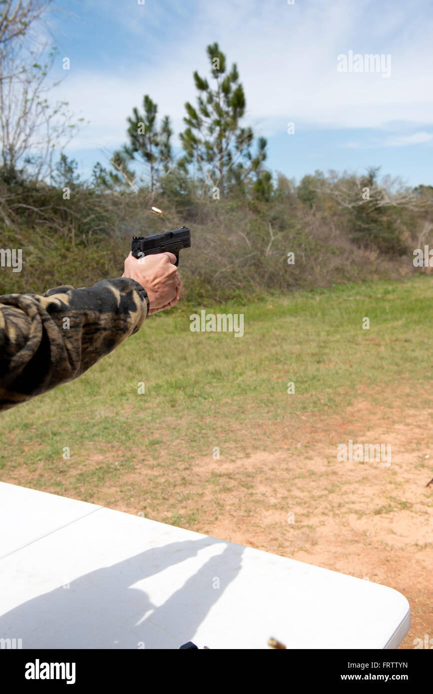 Latin Man Shooting Semi-Auto Handgun Stock Photo