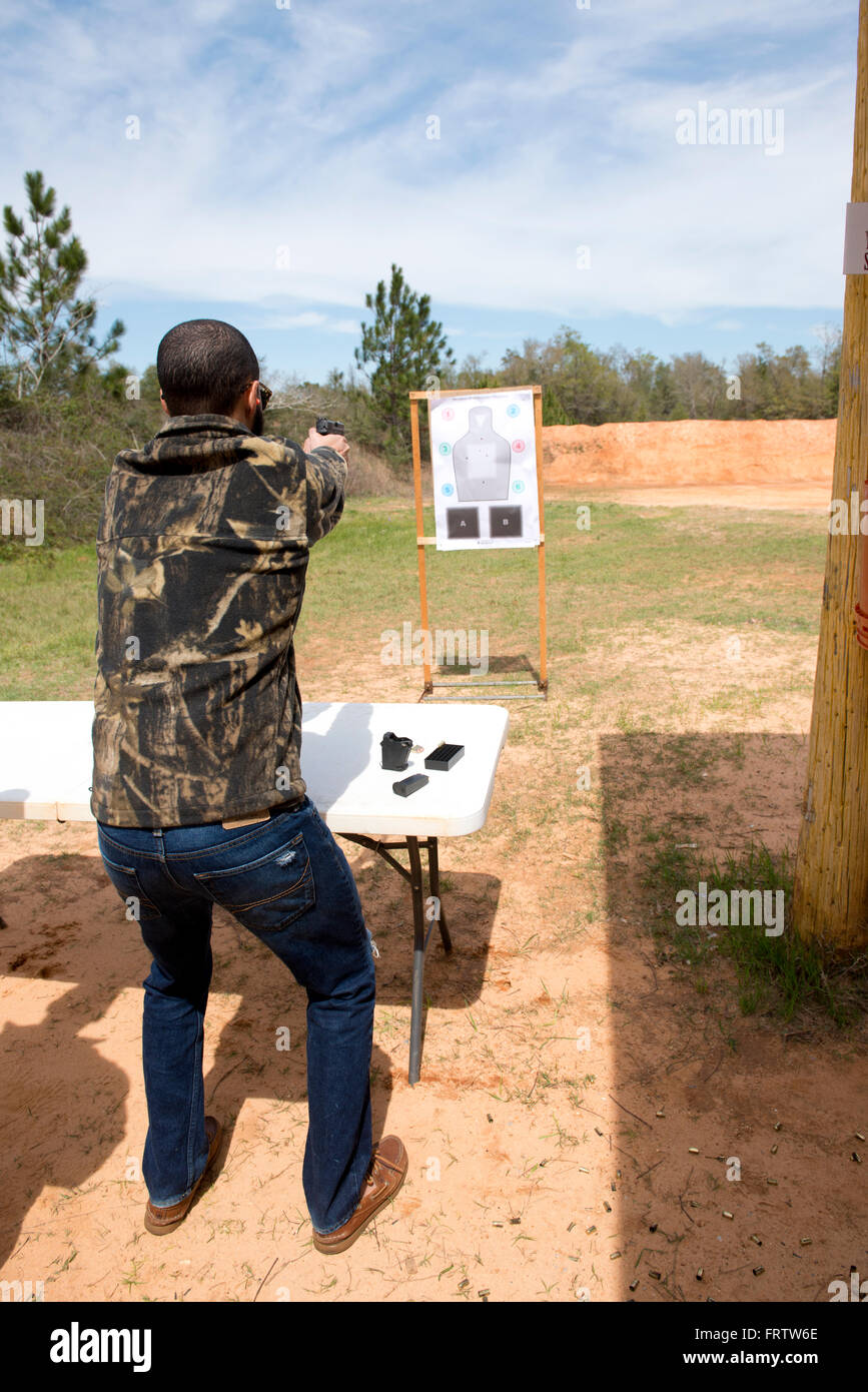 Latin Man Shooting Semi-Auto Handgun Stock Photo