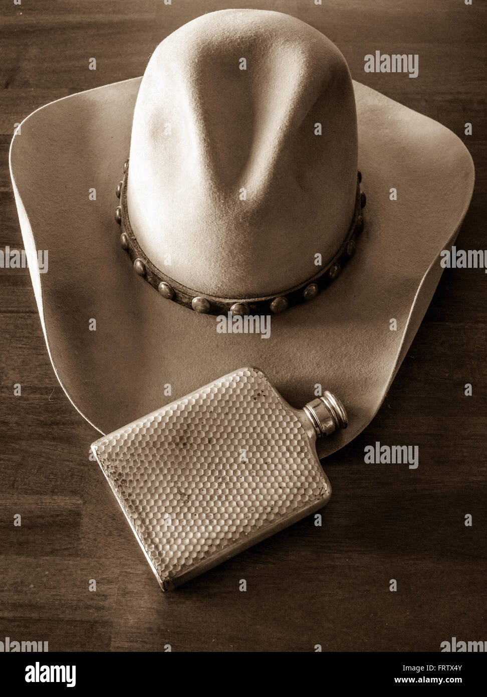 Leather cowboy hat, studded hat band and flask Stock Photo