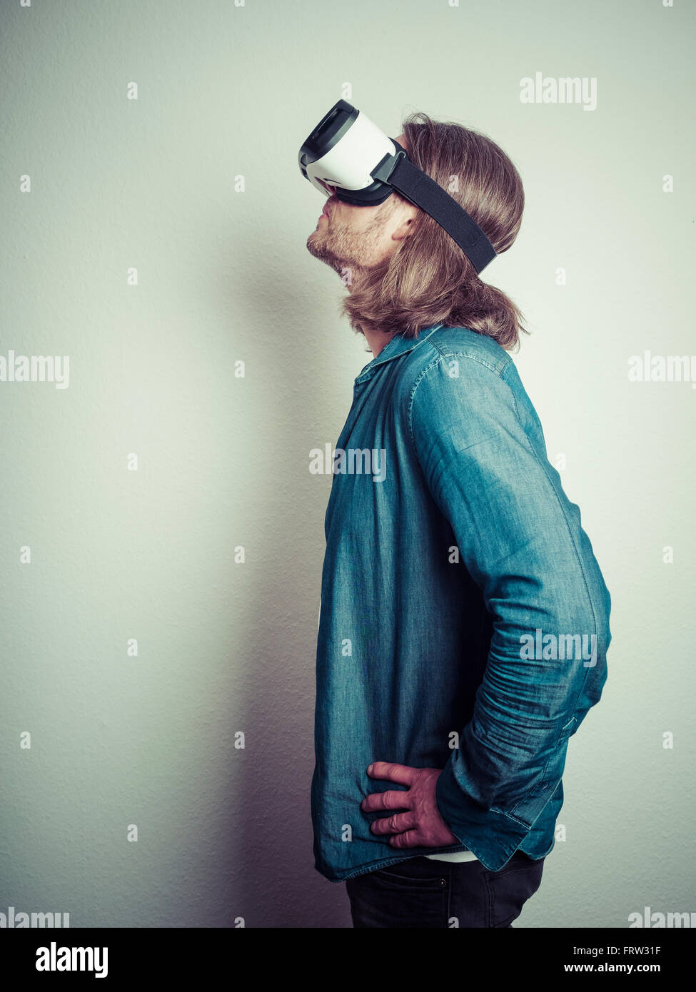 Man with hands on his hips wearing Virtual Reality Glasses looking up ...
