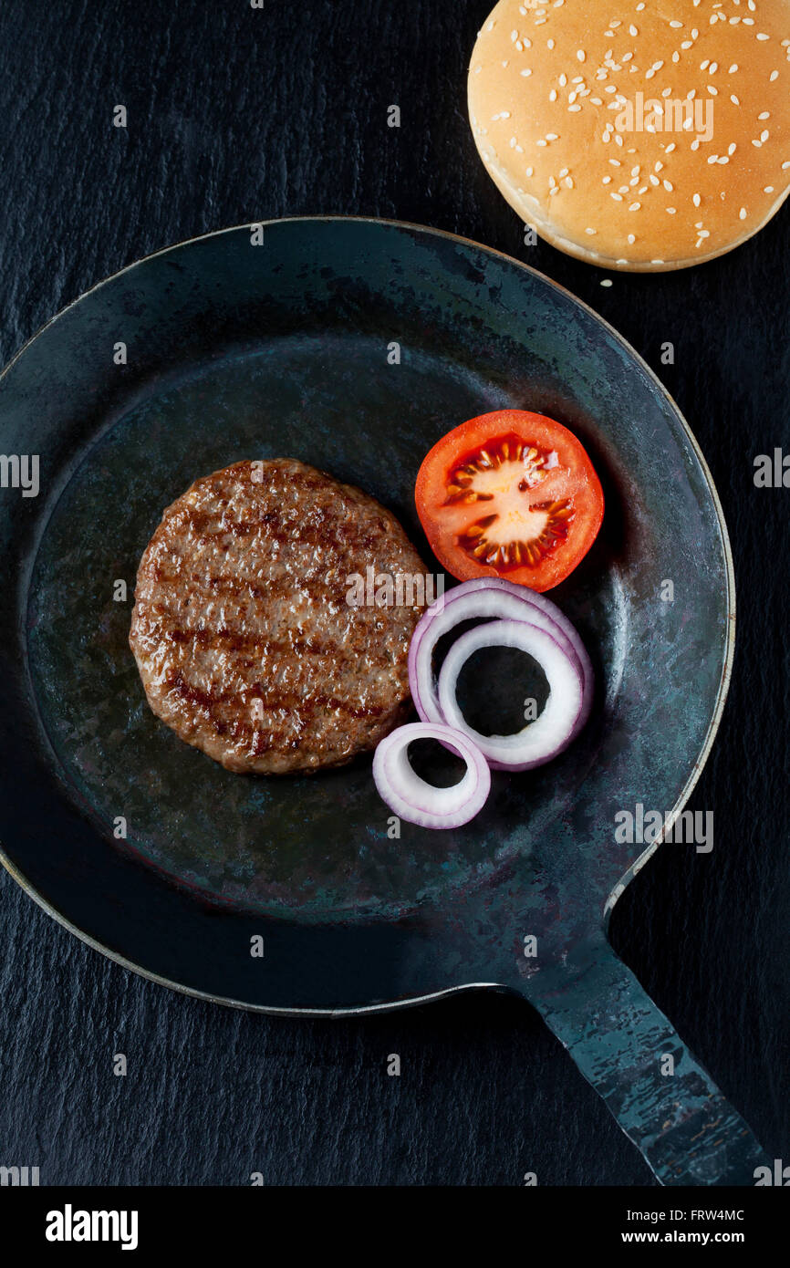 Fried beef patties with onions and tomato in pan Stock Photo Alamy