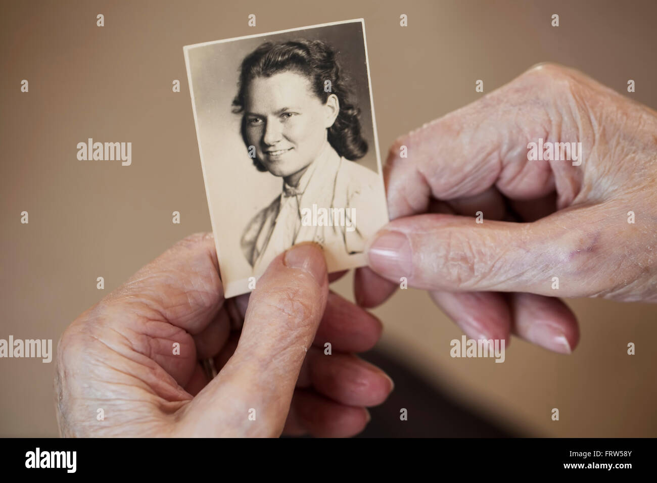Hands of senior woman holding old photography of herself Stock Photo