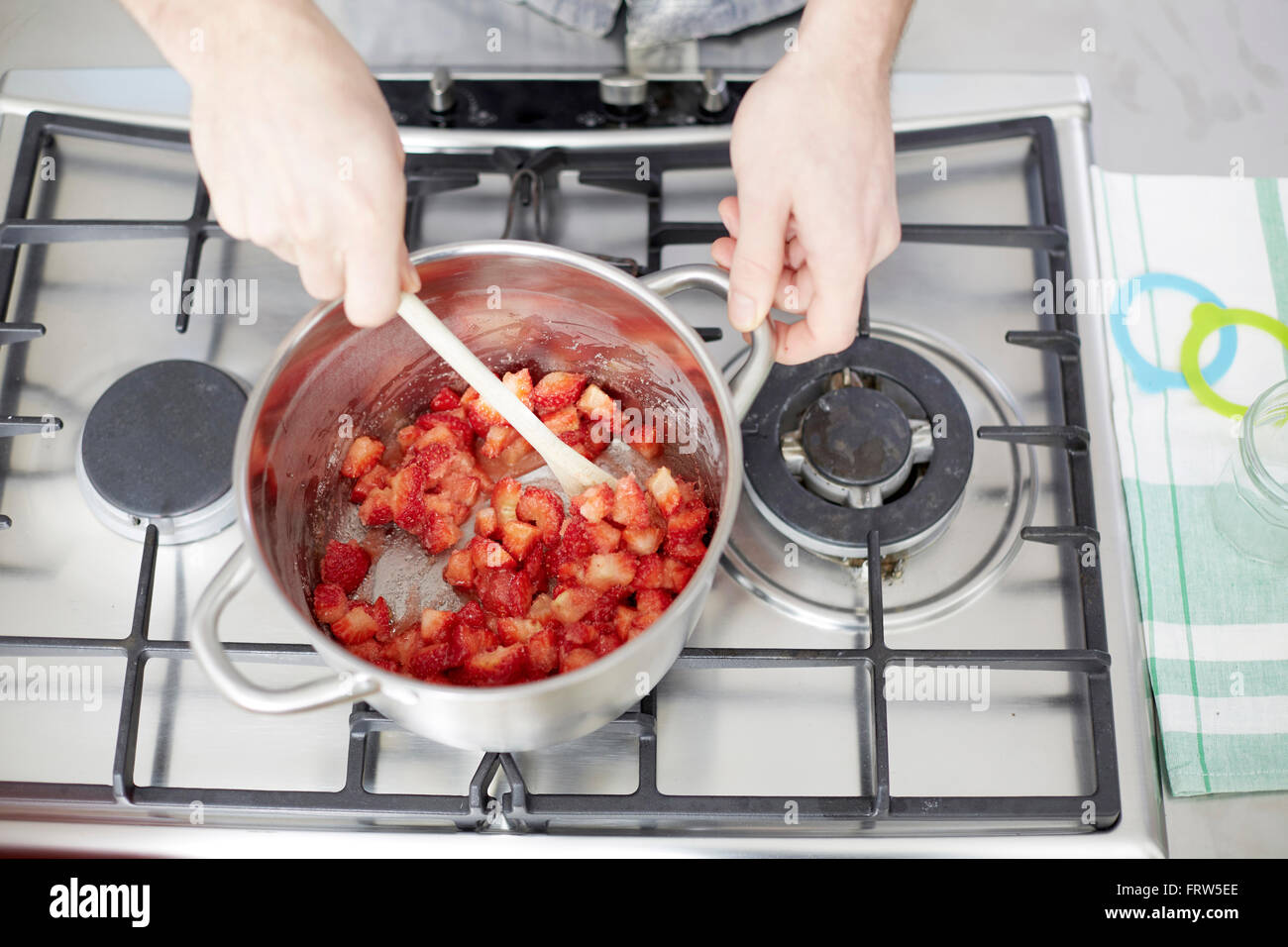 Man stirring strawberries on gas stove Stock Photo Alamy