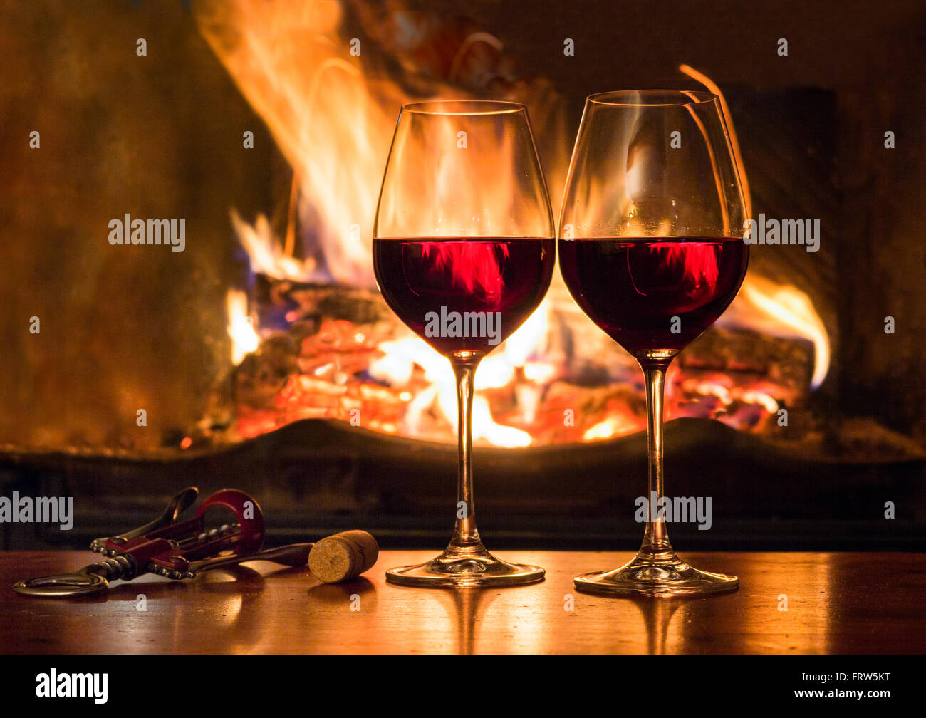 Two glasses of red wine in front of a fireplace Stock Photo - Alamy