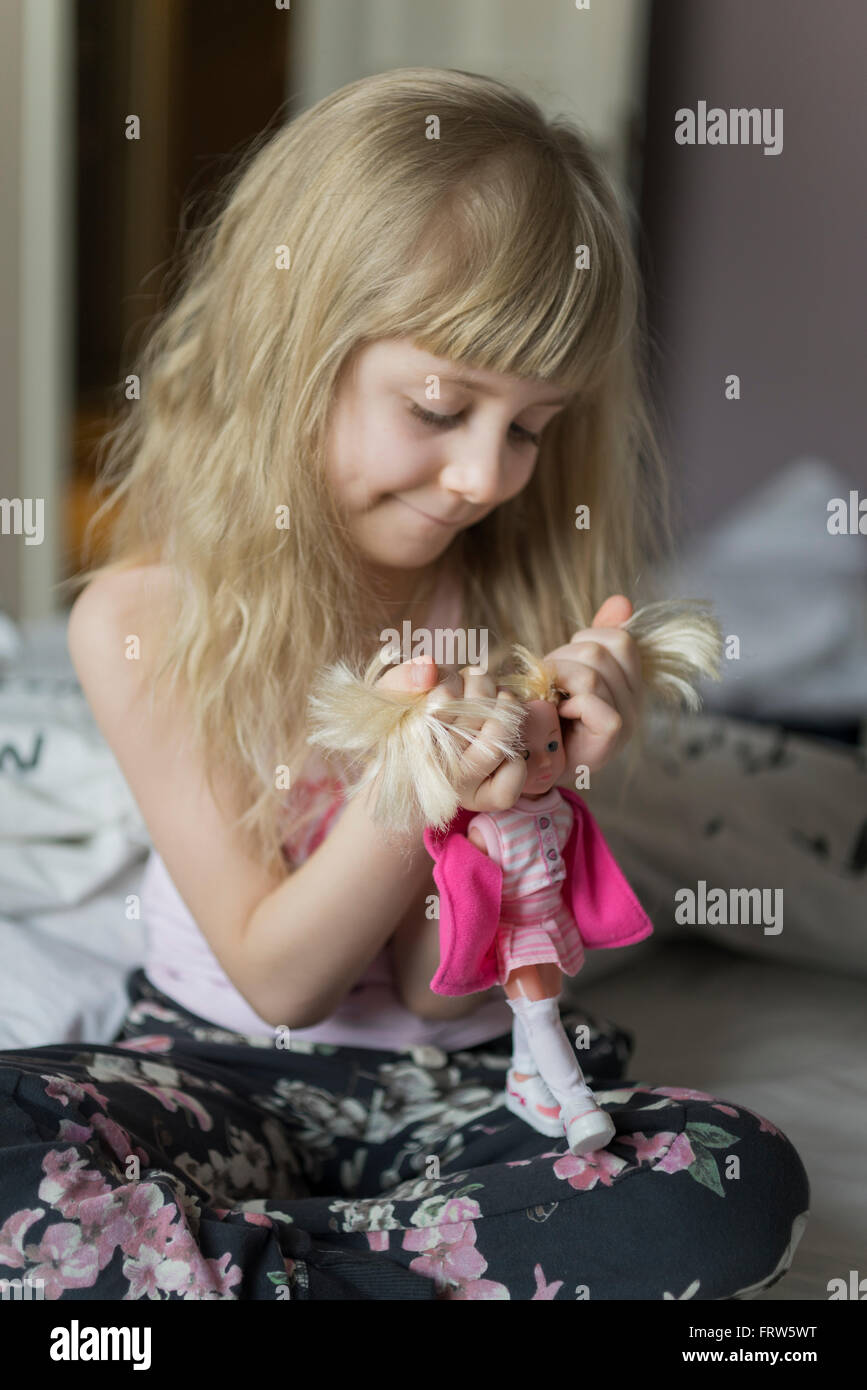 Little girl hairdressing her doll Stock Photo Alamy
