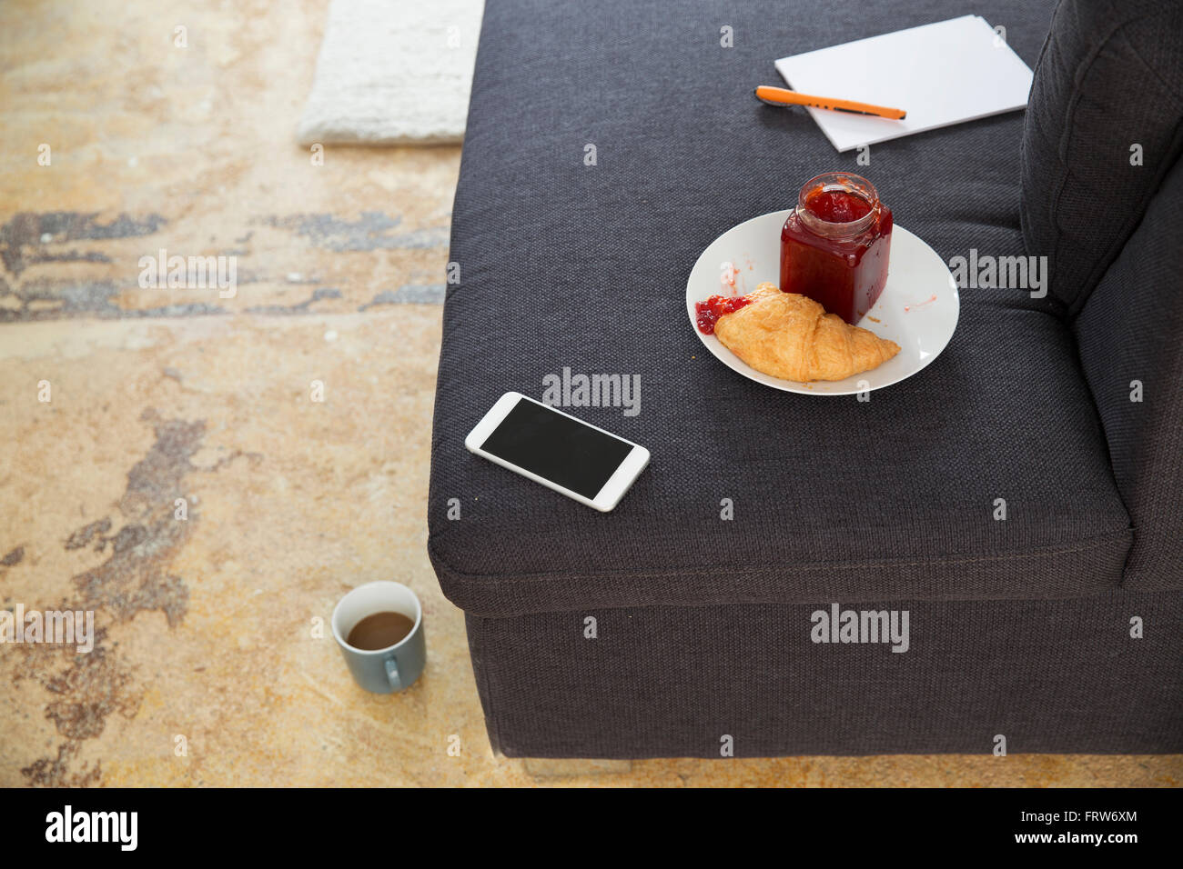 Smartphone and croissant with jam on couch Stock Photo Alamy