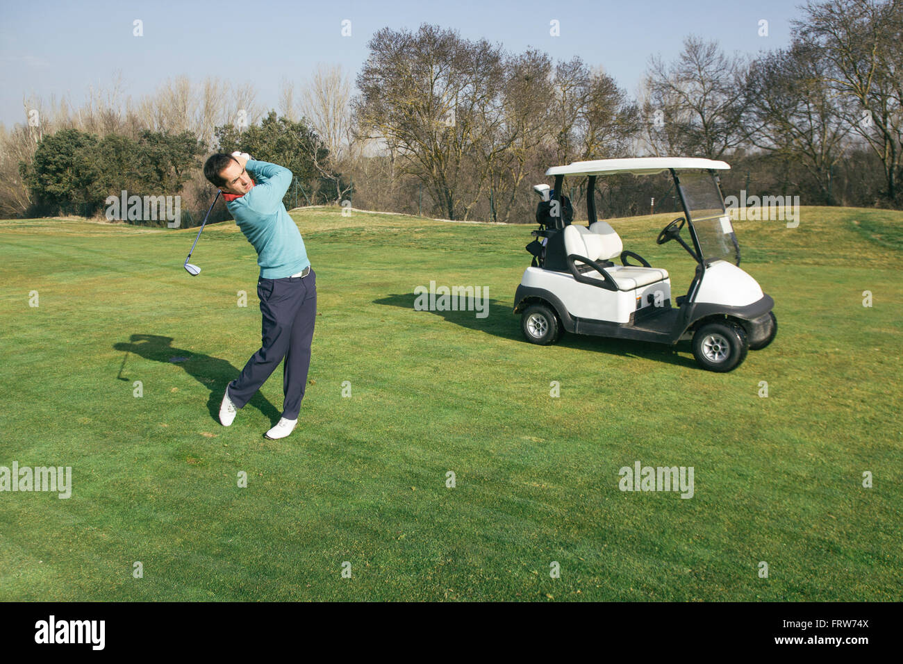 Golfer on a golf course, golf cart Stock Photo Alamy