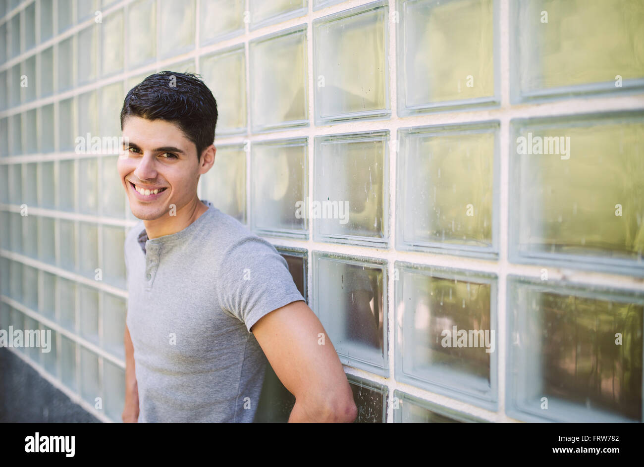 Portrait of smiling young man standing in front of wall Stock Photo - Alamy