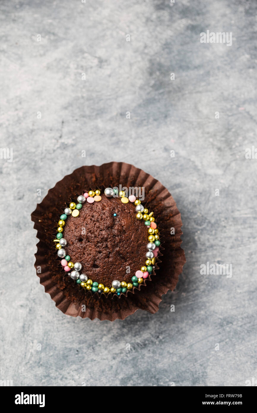 Cupcake with chocolate icing and sugar beads, copy space Stock Photo ...