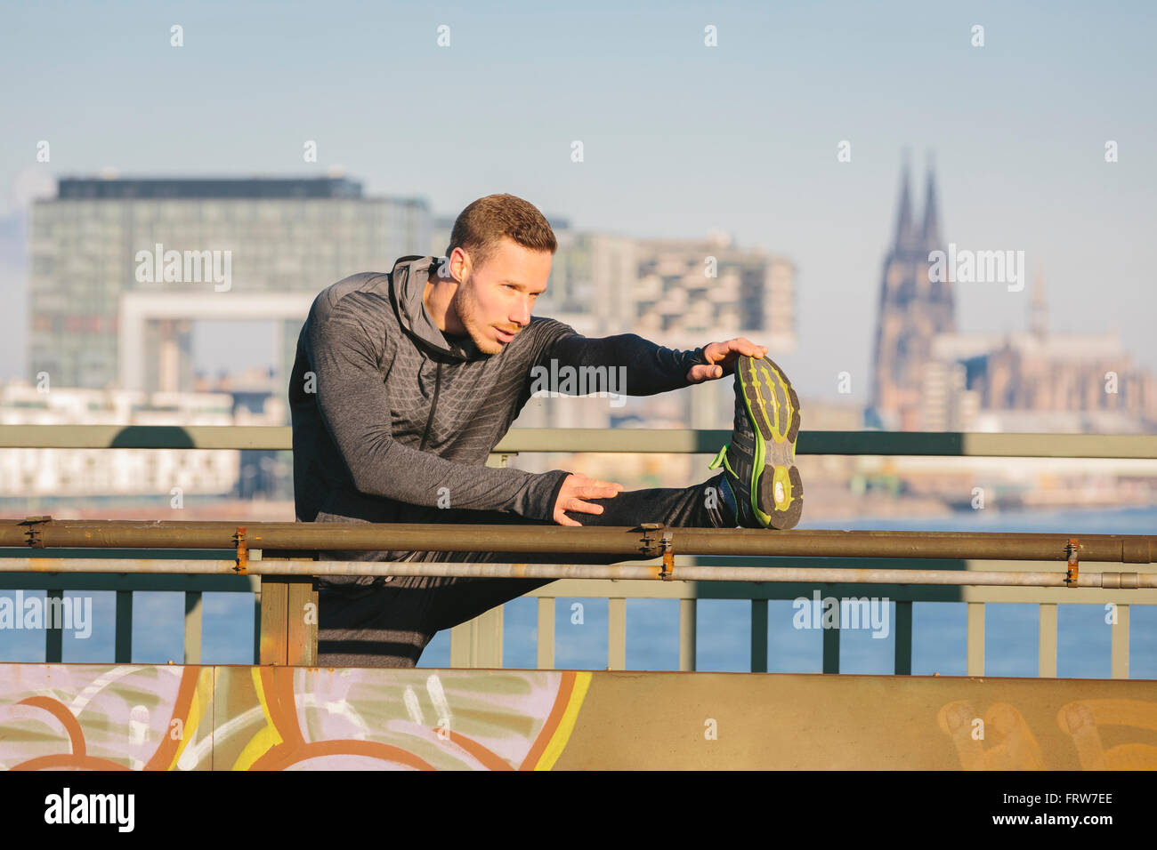Germany, Cologne, Young man worming up for workout Stock Photo