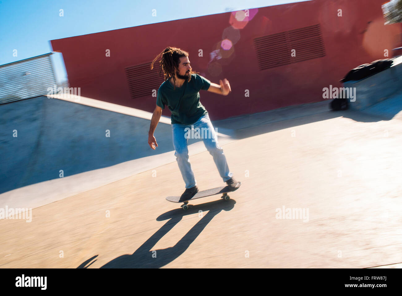 Young man with dreadlocks skateboarding in a skatepark Stock Photo Alamy