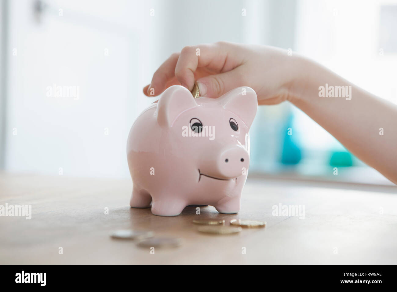 Little boy putting coin into piggy bank, close-up Stock Photo - Alamy