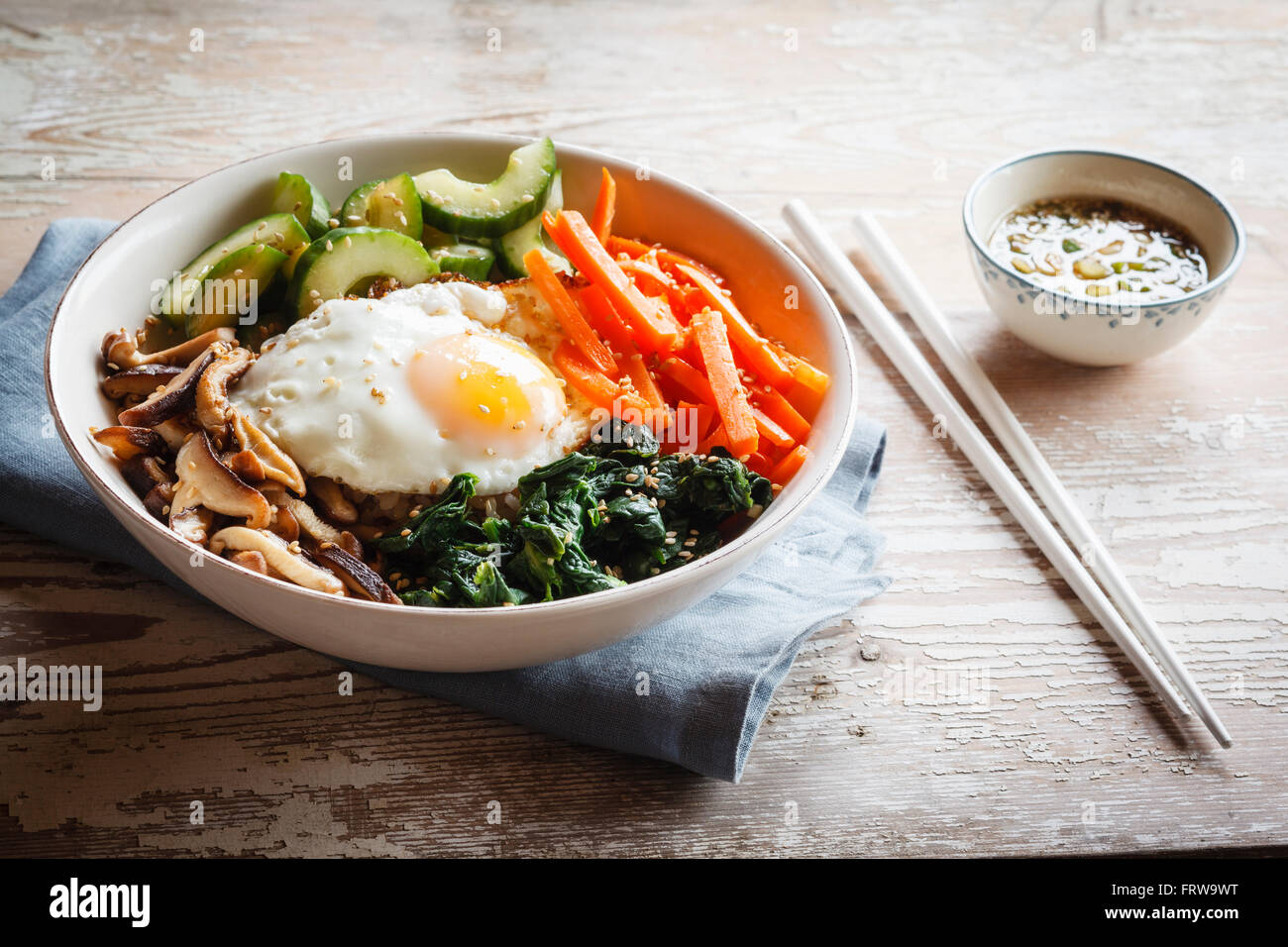 Vegetarian korean rice bowl with mushroom, spinach, cucumber, carrot