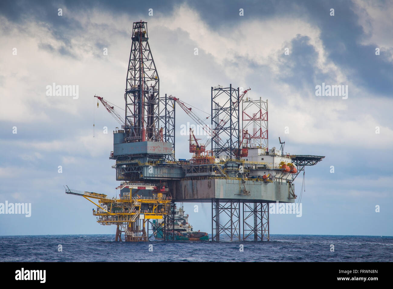 Oil and gas drilling rig work over remote wellhead platform to completion oil and gas produce well by using drilling bit which m Stock Photo