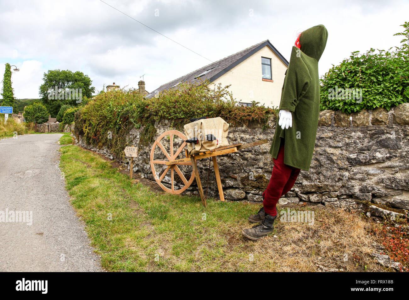 A wheel barrow and model of a man signifying the contaminated cloth that brought the plague or black death to Eyam Derbyshire Stock Photo
