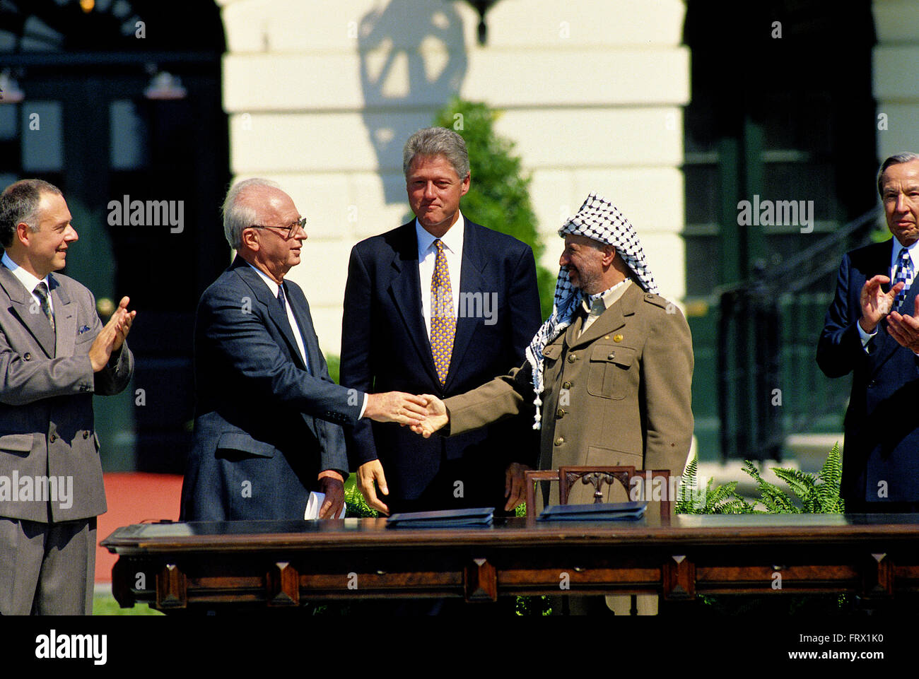 Washington, DC., USA, 13th September, 1993 President William Jefferson Clinton hosts the Palestinian  Peace Accords treaty signing on the South Lawn of the White House. Prime Minister Yitzhak Rabin of Israel and the Palestine Liberation Organization chairman, Yasser Arafat, shake hands in a public ceremony at the White House after signing an agreement that granted limited autonomy to Palestine and laid the foundation for future peace talks. Credit: Mark Reinstein Stock Photo