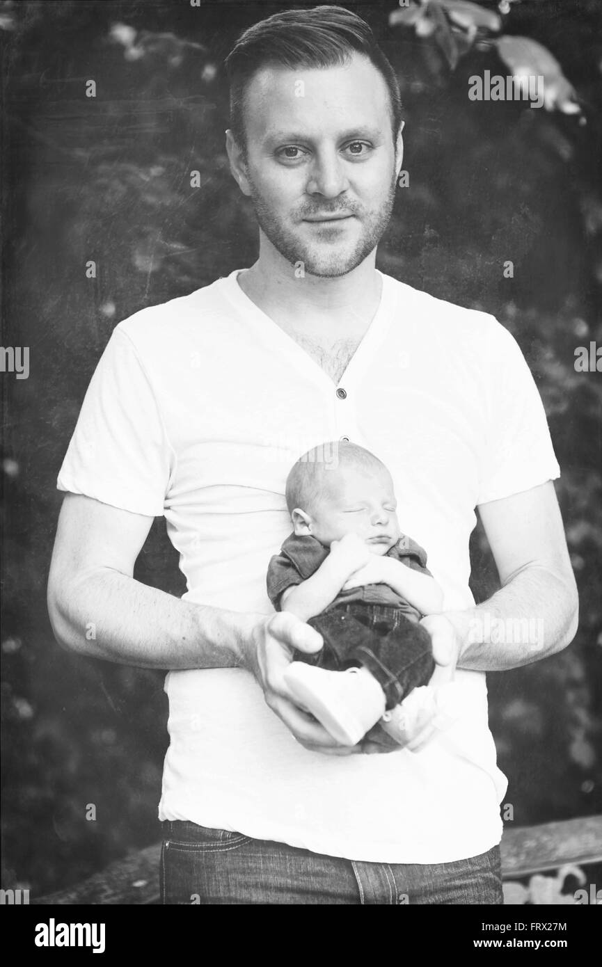 Black and white image of a new father holding his newborn son. Stock Photo