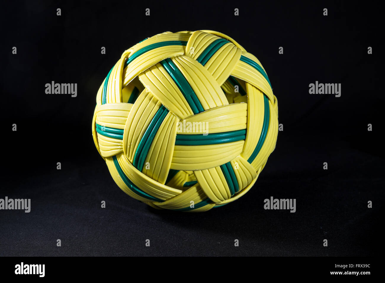Yellow and green rattan ball for playing sepak, a traditional game in Malaysia. Originally made from rotting Stock Photo