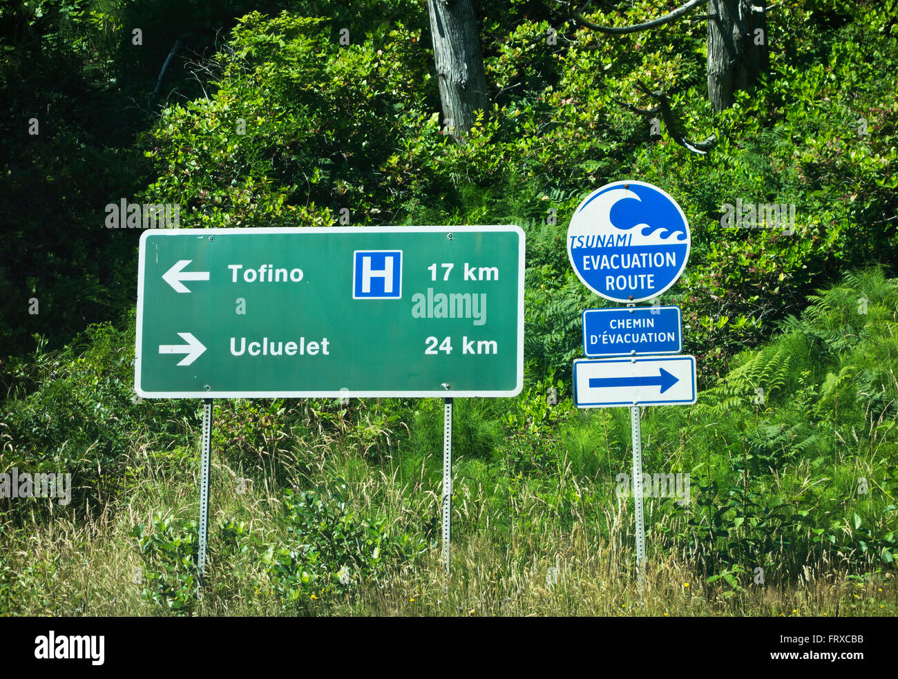 Sign for Tofino and Ucluelet and for the Tsunami Evacuation Route.  Bilingual in French writing. Long Beach, BC, Canada Stock Photo