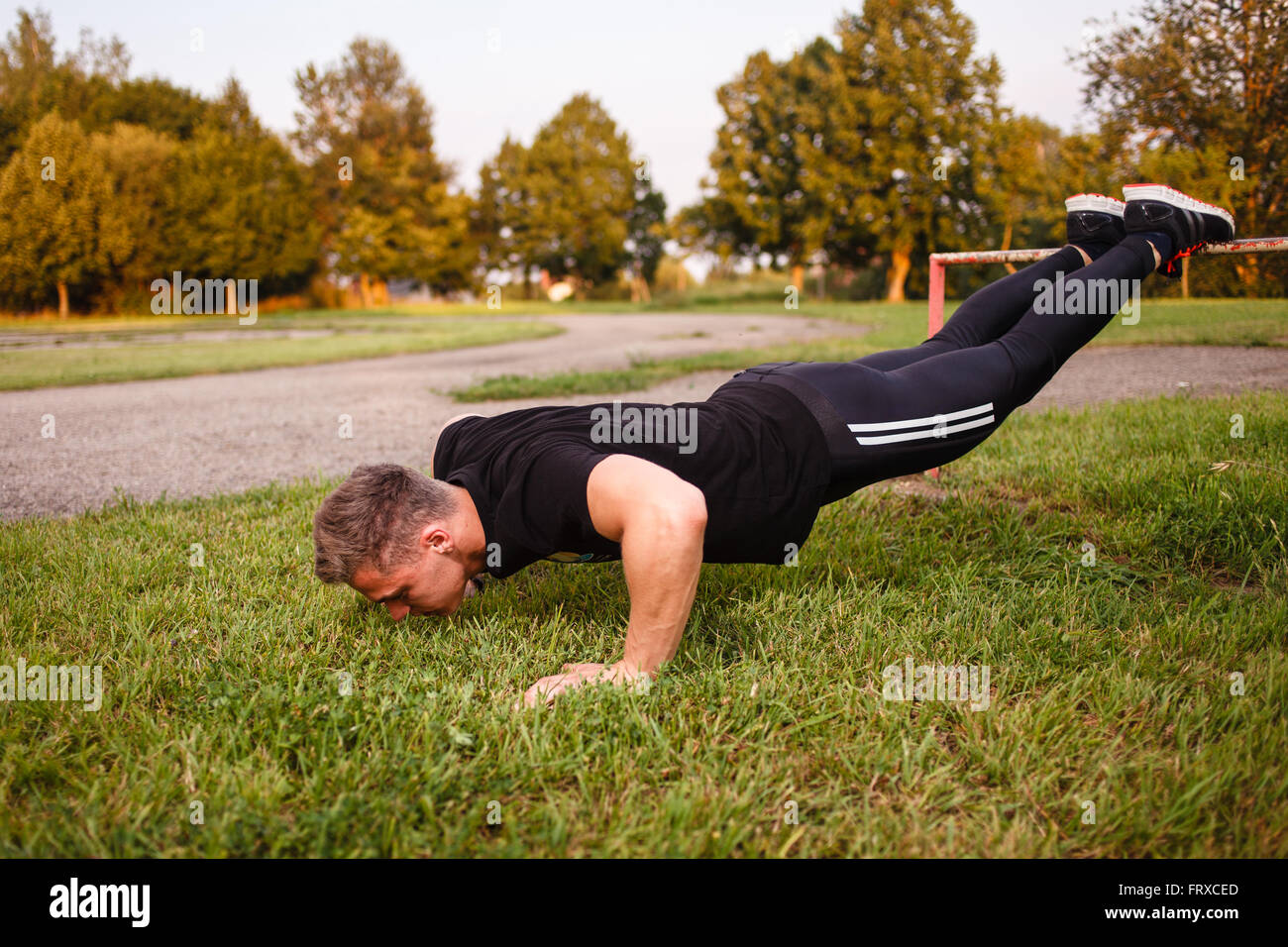 Young man doing push-up outdoor. Stock Photo