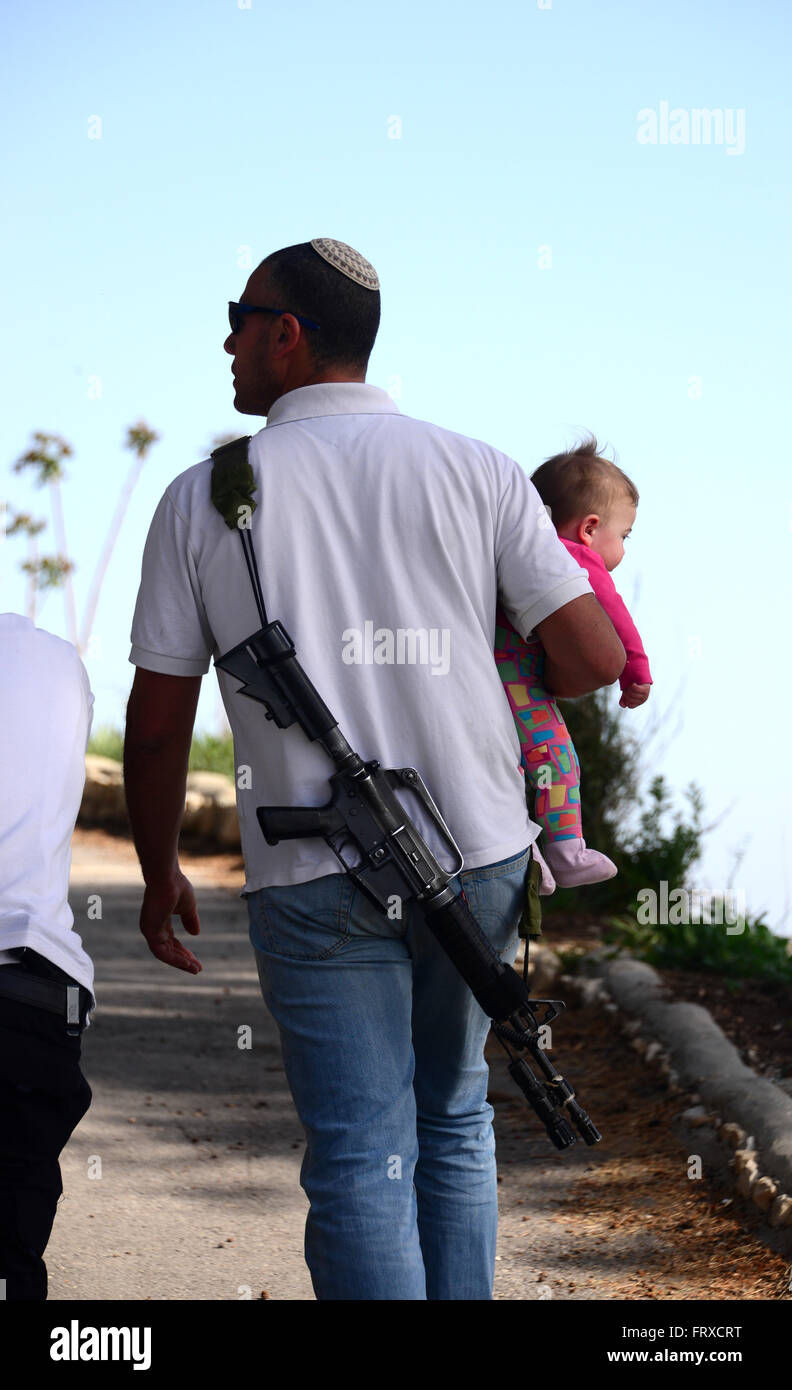 Israeli man carrying weapon and child, Israel Stock Photo