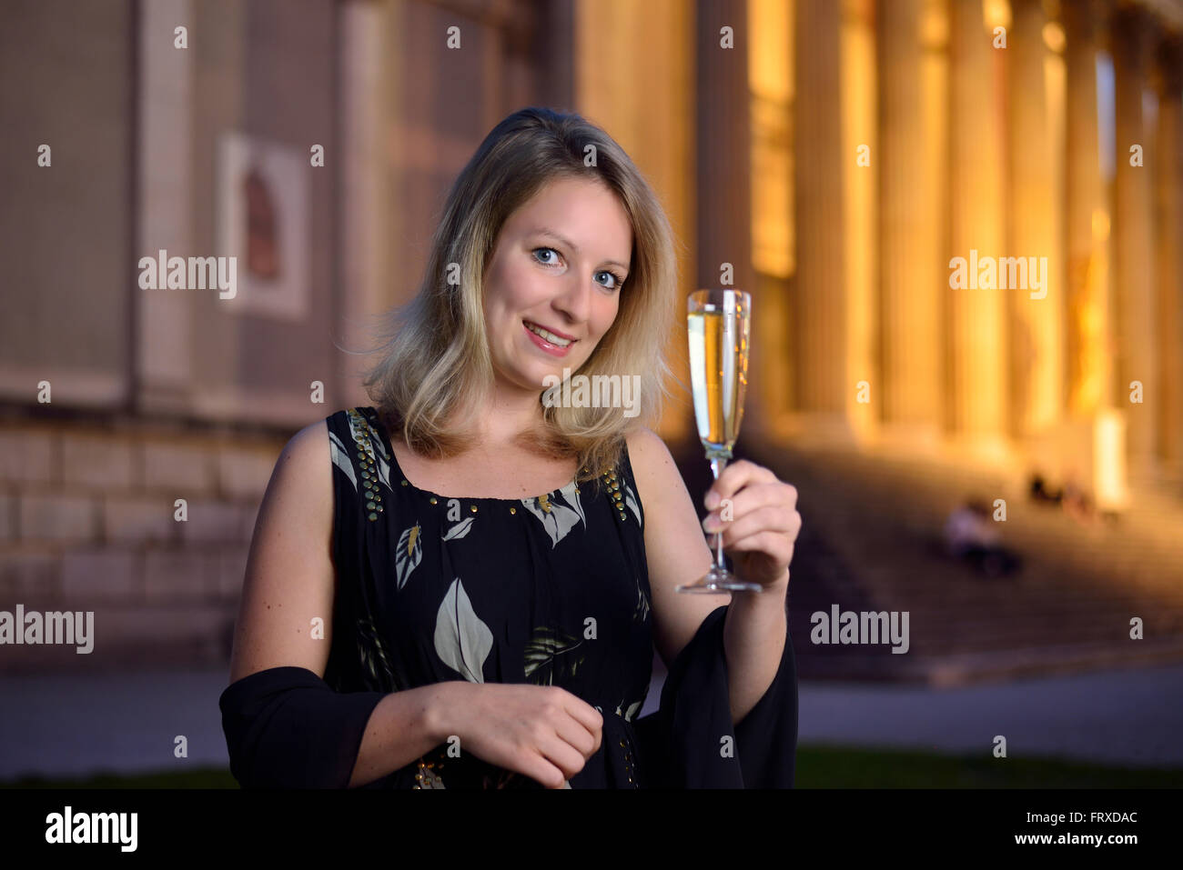 Young woman holding a glass of champagne, Staatliche Antikensammlung, Koenigsplatz, Munich, Upper Bavaria, Bavaria, Germany Stock Photo