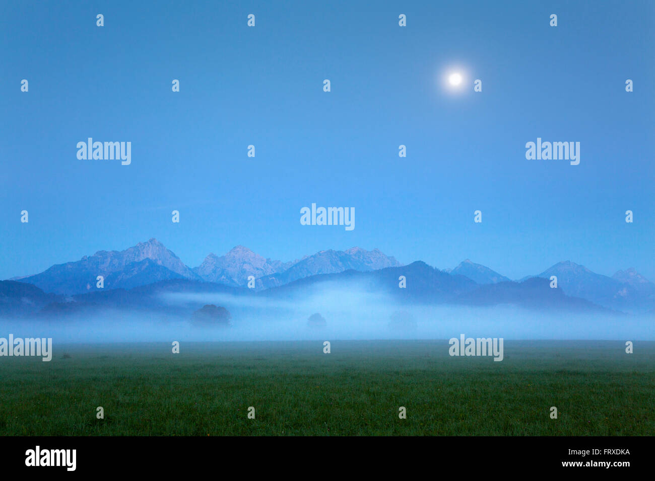 Tannheim mountains in the morning mist and moonlight, Hohenschwangau, near Fuessen, Allgaeu, Bavaria, Germany Stock Photo