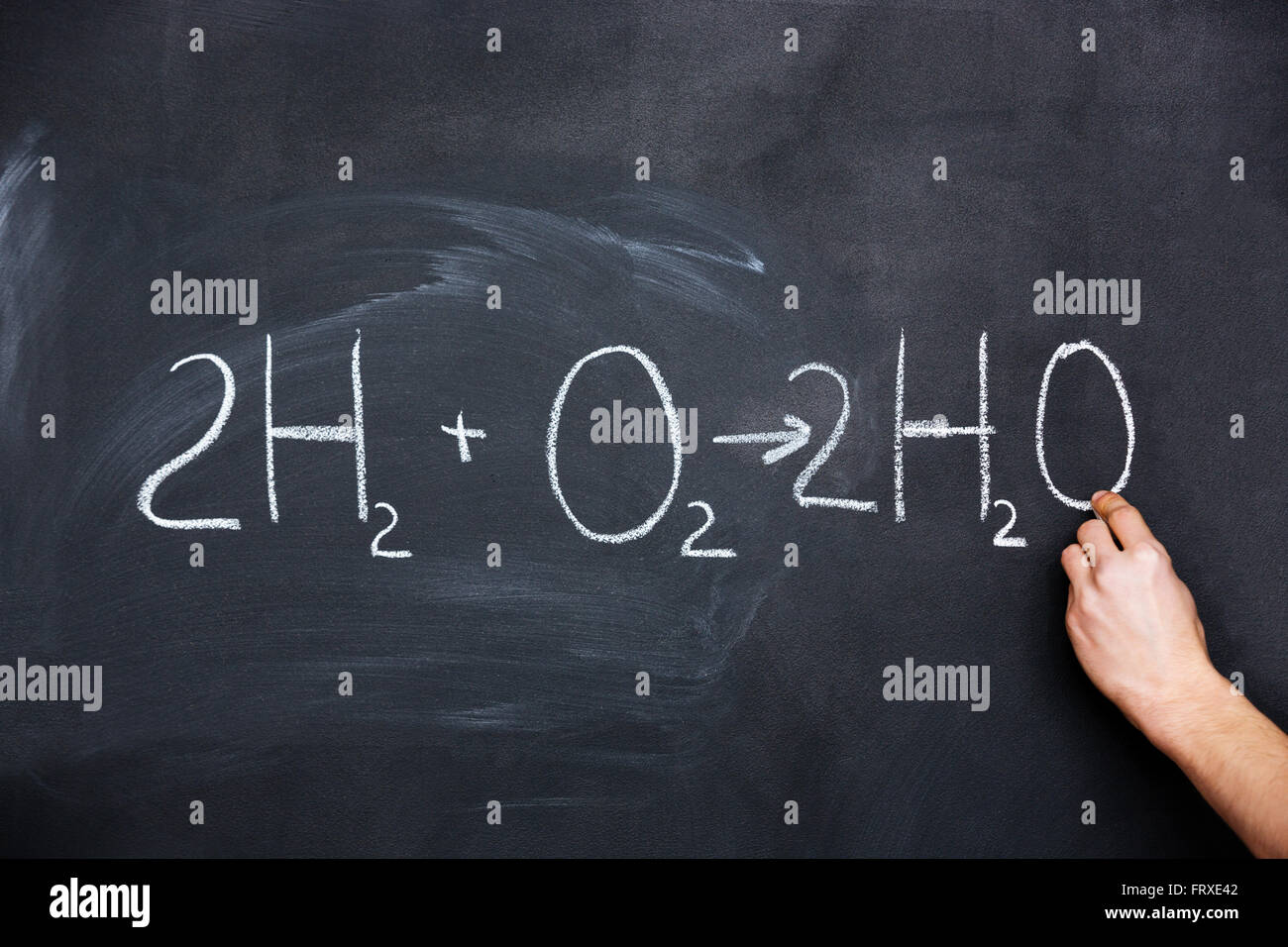 Hand writing chemical formula on blackboard with chalk Stock Photo