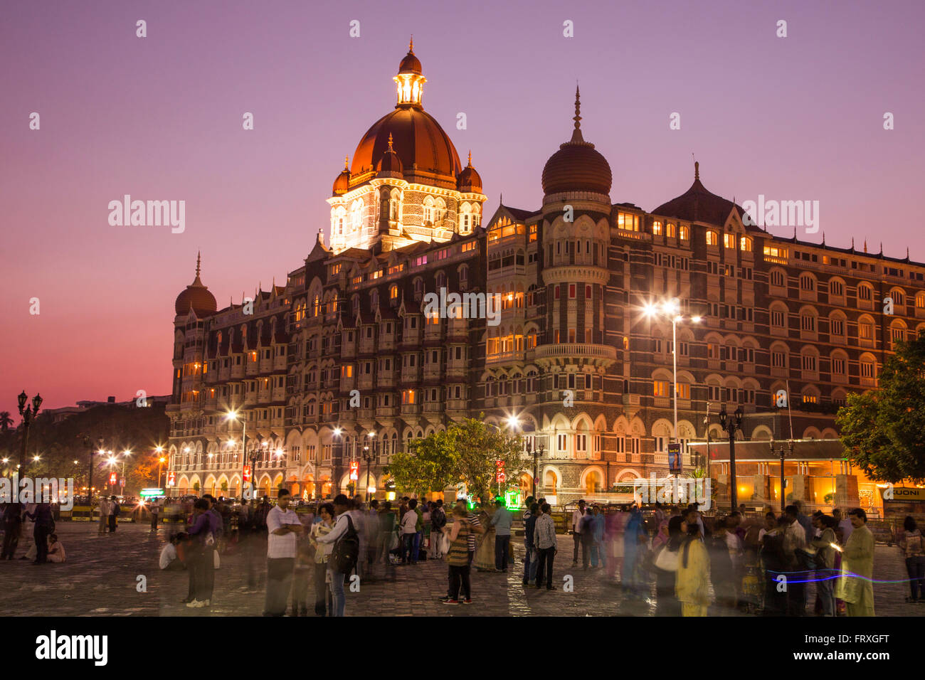 People on Wellington Pier and The Taj Mahal Palace Hotel at dusk, Mumbai, Maharashtra, India Stock Photo