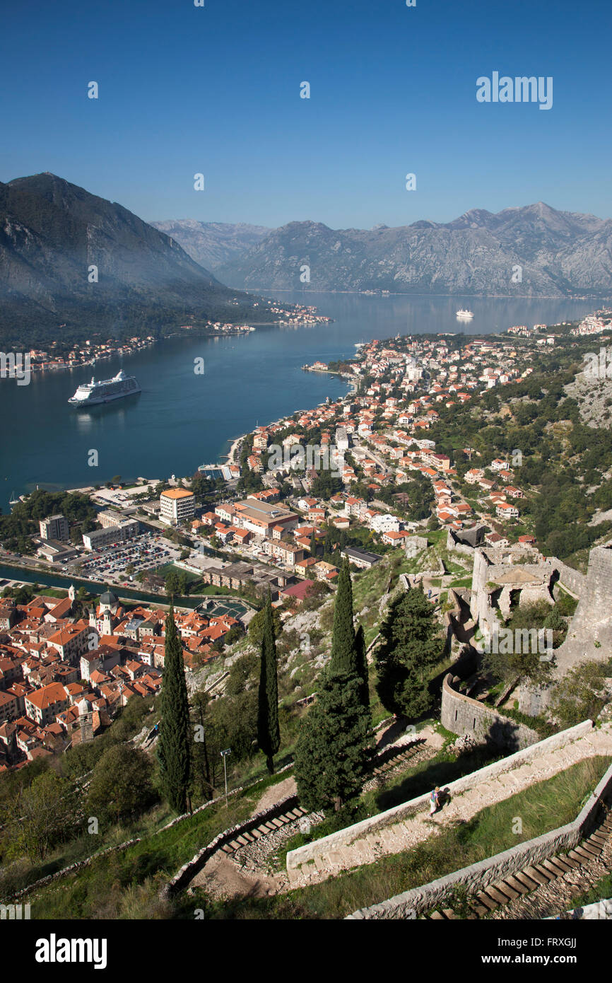 Steep walkway to fortress and view over Old Town and cruise ships Seven Seas Voyager, Regent Cruises, and MS Deutschland, Reederei Peter Deilmann, in Kotor Fjord, Kotor, Montenegro Stock Photo