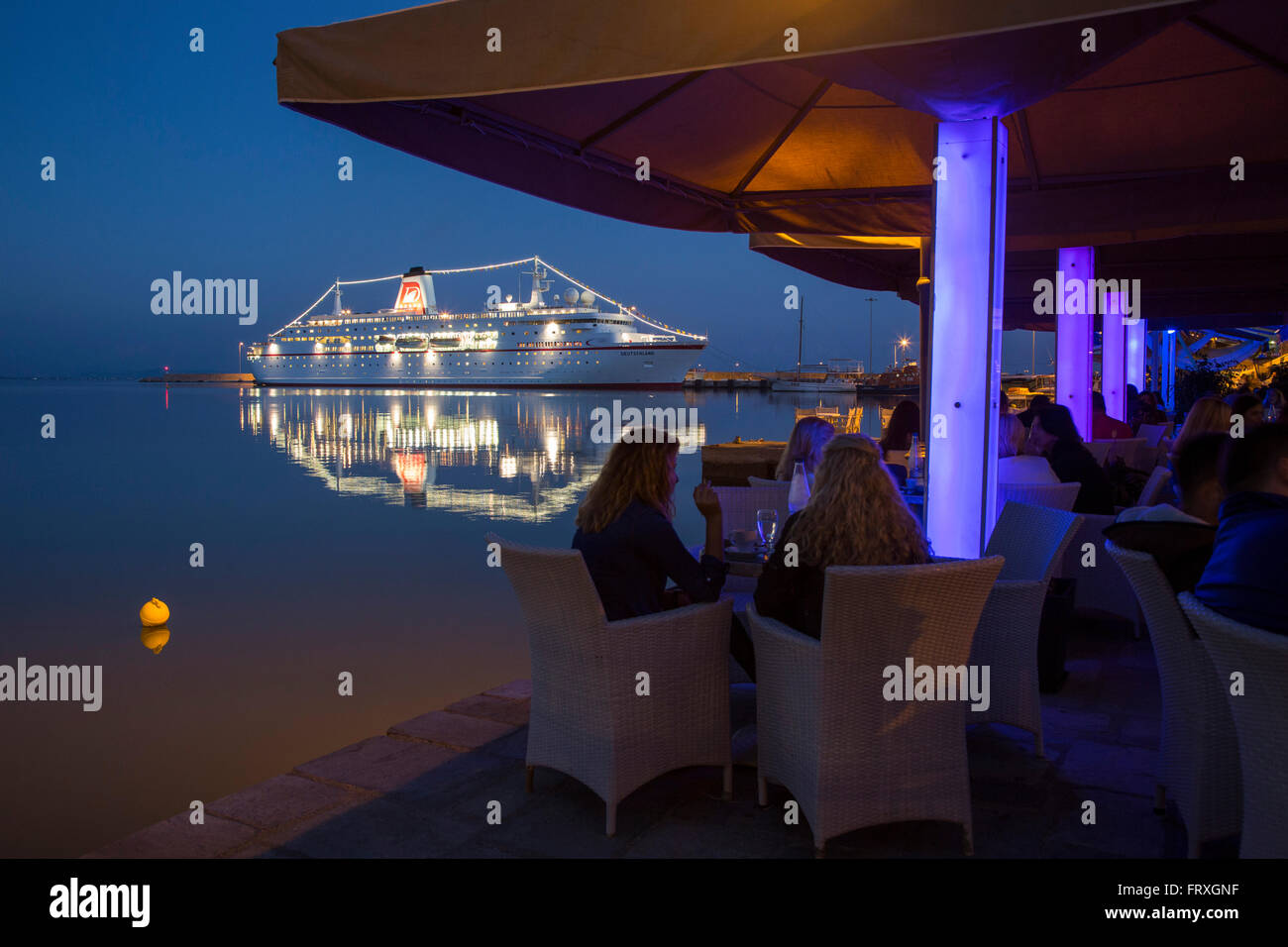 People in a restaurant in the evening with the cruise ship MS Deutschland, Reederei Peter Deilmann at the pier , Katakolon, Pyrgos, Peloponnese, Greece Stock Photo