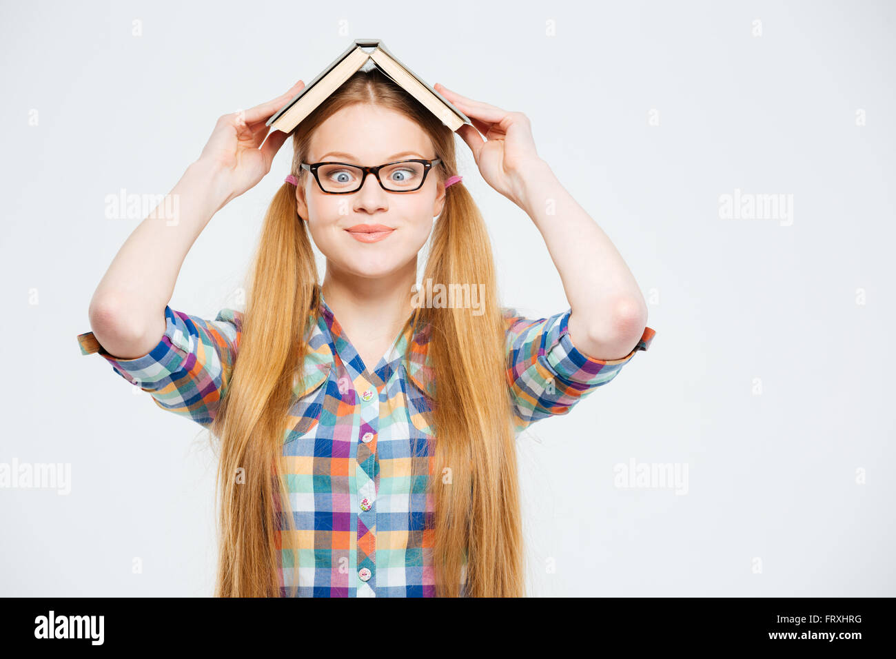 Funny female student with book on head isolated on a white background ...