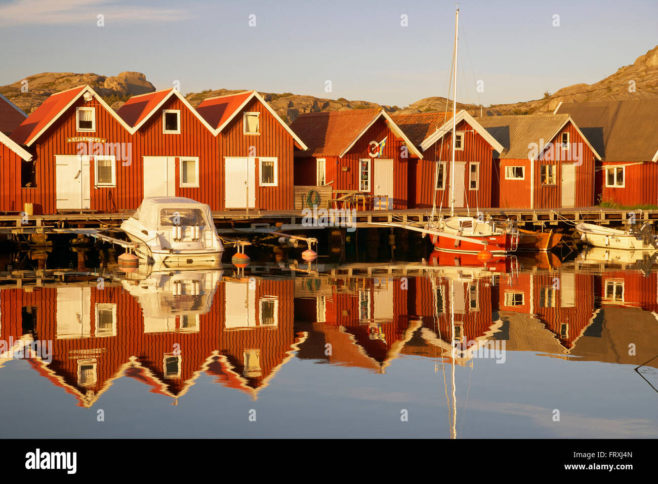 Boats and boot houses in Bleket port reflecting in the water, Tjoern Island, Province of Bohuslaen, West coast, Sweden, Europe Stock Photo